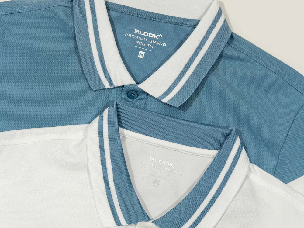 Playeras tipo polo en azul y blanco dobladas, listas para entrega